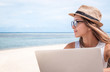 Young woman freelancer working on the beach