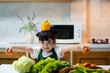 © Asada - Asian kid in the kitchen at home. Kid enjoy cooking the healthy food with variety of vegetable.