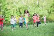 © Andrey - A group of happy children of boys and girls run in the Park on the grass on a Sunny summer day . The concept of ethnic friendship, peace, kindness, childhood.