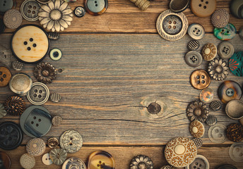 placer of vintage buttons with copy space on textured old boards