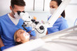 © gpointstudio - Male dentist looking through dental microscope