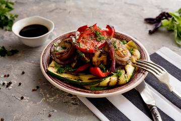 ingridients. baked vegetables with soy sauce. top view. homeamde. black plate. zucchini, pepper, oni