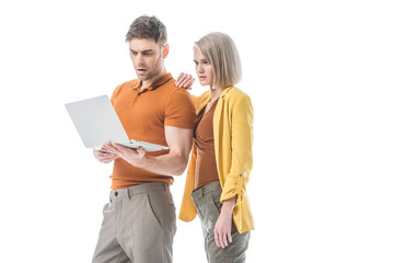 Wall Mural - surprised man and  serious woman using laptop together isolated on white