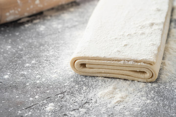 Fresh raw dough on table. Puff pastry. Copy space.