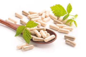 Herbal medical capsule with green leaf isolated