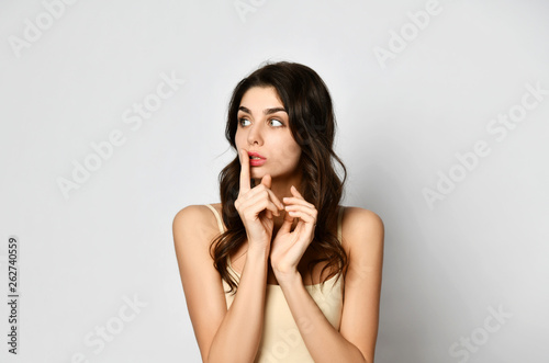 A Bit Scared Beautiful Woman Holds Her Finger At Her Mouth And