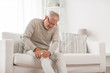 © Syda Productions - people, health care and problem concept - unhappy senior man suffering from knee ache at home