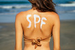 © yurakrasil - back and shoulders neck close up beautiful young woman in sexy bikini at the beach sunscreen