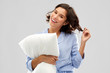 © Syda Productions - people and bedtime concept - happy young woman in pajama hugging pillow over grey background