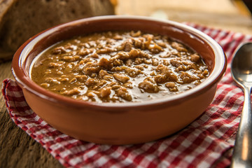 Wall Mural - tripe stew sauce in brown ceramic pot on a wood table 