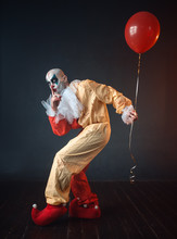 Bloody Clown In Carnival Costume Holds Air Balloon
