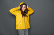 © Yakobchuk Olena - Cropped photo of happy Caucasian girl dressed in yellow raincoat in studio