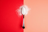 Fototapeta  - sugar with spoon on red and yellow background