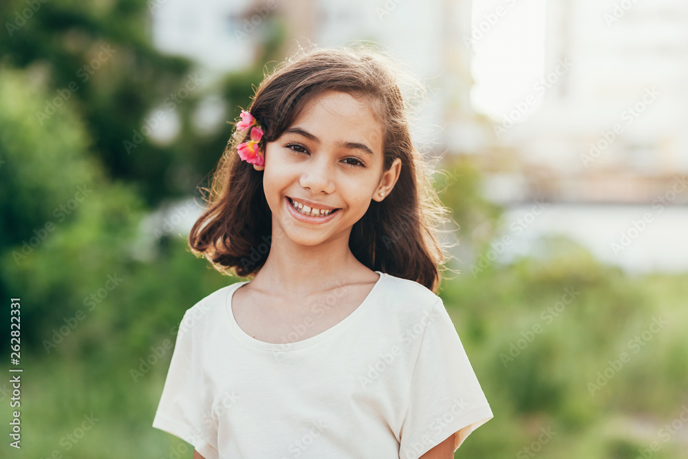 Cute little girl with a flower in her hair Stock Photo | Adobe Stock