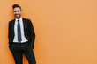 © Antonio Ovejero/ADDICTIVE STOCK - Adult handsome elegant businessman in formal suit looking at camera near orange wall