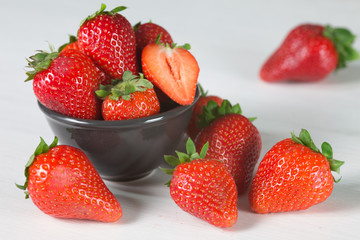 Heap of fresh strawberries in woods on rustic white wooden background 