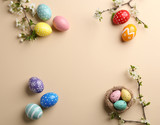 Fototapeta Mapy - Flat lay composition with painted Easter eggs and blossoming branches on color background, space for text