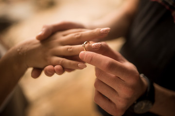 hands of couple in love with a ring of marriage proposal on the tropical beach in Bali