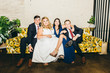 © Leah Flores/Stocksy - Bride and Her Siblings Sit on Couch for Portrait