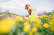 © Jovana Rikalo/Stocksy - Young woman in dandelion field in early spring