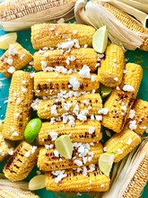 Corn Cobb  On Green Wood With Limes And Feta Cheese.