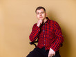 © Karyna - Elegant man siting and posing on brown background. Thinking about difficulty of life. Concept for blog, lifestyle