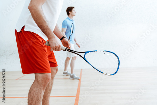  Fototapeta Squash   czesciowy-widok-dwoch-graczy-w-squasha-z-rakietami-na-boisku-czterosciennym
