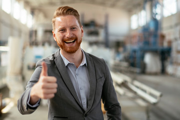 Businessman in a factory. Manager shows thumb up. 