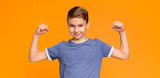 Smiling boy demonstrating his biceps and muscles