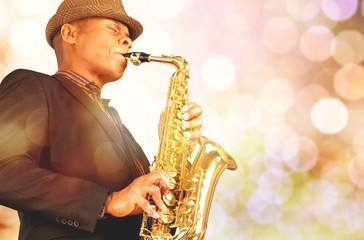 Wall Mural - Close-up man playing on saxophone on blurred background