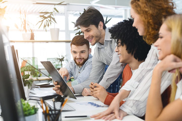 Poster - Young cheerful people looking at clipboard at coworking workplace