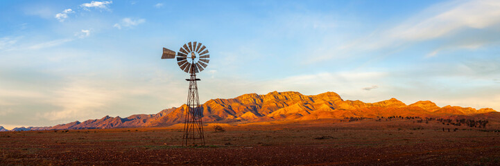 a windmill with the flinders ranges behind it in the australian outback. flinders ranges national pa