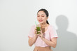 © makistock - Go green. Young beautiful woman enjoying a healthy raw fruit vegetable juice. Studio shot.