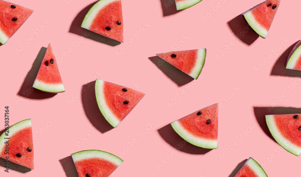 Sliced watermelons arranged on a pink background - obrazy, fototapety, plakaty 