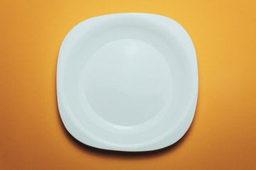 Poster - White bowl and a fork with a spoon on an orange background