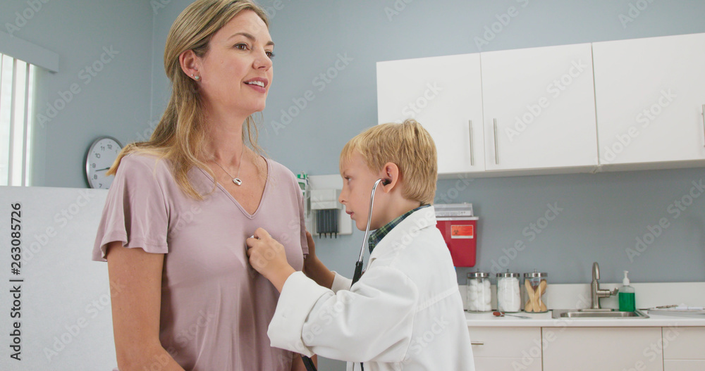 Cute little boy pretending to be a doctor with his mother while in ...
