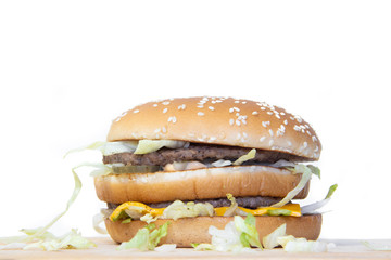 Burger on a white background. Cutlets bun sesame, cheese salad dressing. Improper nutrition. Unhealthy food.