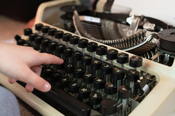Fototapete - Hands writing on an old typewriter. retro-style. keyboard and font