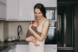 Young mother, holding tenderly her newborn baby girl, close portrait