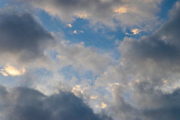 the early light of dawn catching high clouds in a deep blue sky with clouds in shadow beneath.