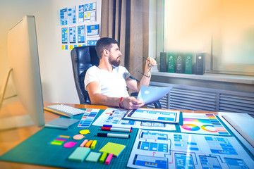 Poster - male graphic designer at the desk. design for mobile devices. close-up pictures of the application d