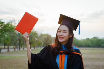 Female university graduate celebrates graduation ceremony receiving degree certificate happily with excitement.