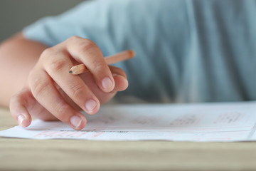 Wall Mural - education test exam in school concept : university student holding pencil notes paper on answer shee