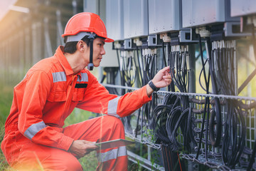 Electrical and instrument technician use touch pad for guide to maintenance electric system at electric solar plant