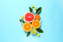 Flat Lay Composition With Citrus Fruits, Leaves And Flowers On Color Background