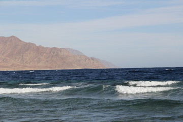 Sea with waves and mountains on the horizon