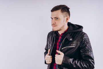 Wall Mural - Man in trendy jacket on white background Portrait of young male in leather jacket zipping up and smiling at camera on white background