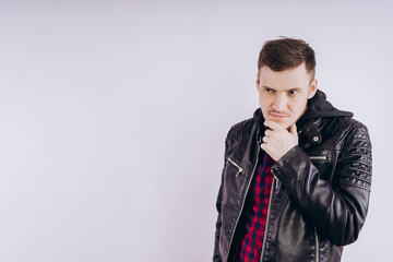 Wall Mural - Man in trendy jacket on white background. Portrait of young male in leather jacket zipping up and smiling at camera on white background