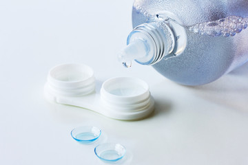 Wall Mural - Contact lenses, case and bottle with solution on white background. Eye health and care, eyesight and vision, ophthalmology and optometry