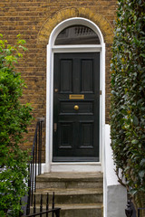 Wall Mural - Black Wooden Entrance Door to residential building in London. Typical door in the English style.